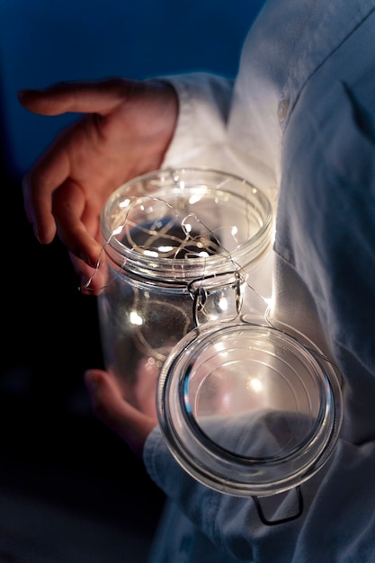 Free photo view of hands holding jar of lights