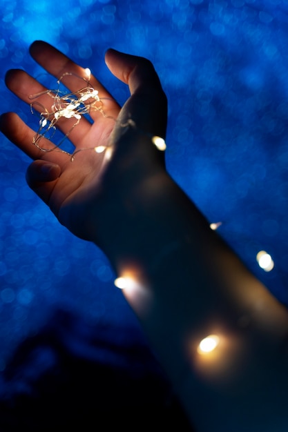 Free photo view of hands tiny lights