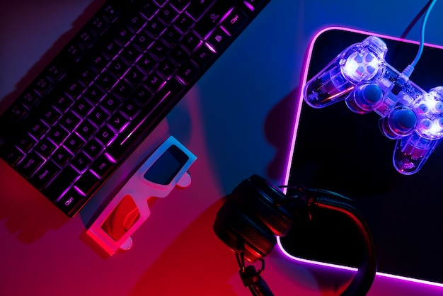 View of illuminated neon gaming keyboard setup and controller