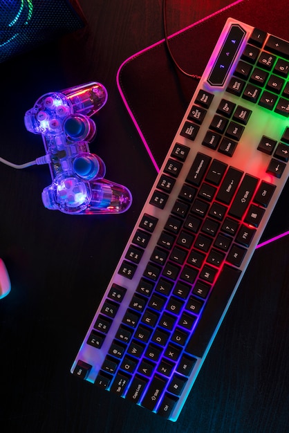 Free photo view of illuminated neon gaming keyboard setup and controller