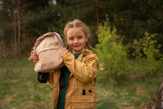 Free photo view of little girl with backpack adventuring in nature