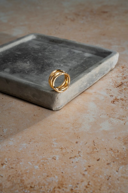 Free photo view of luxurious golden ring on rock or concrete tray