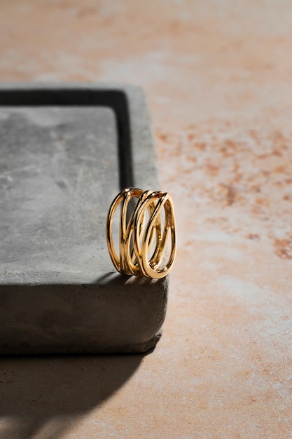 Free photo view of luxurious golden ring on rock or concrete tray