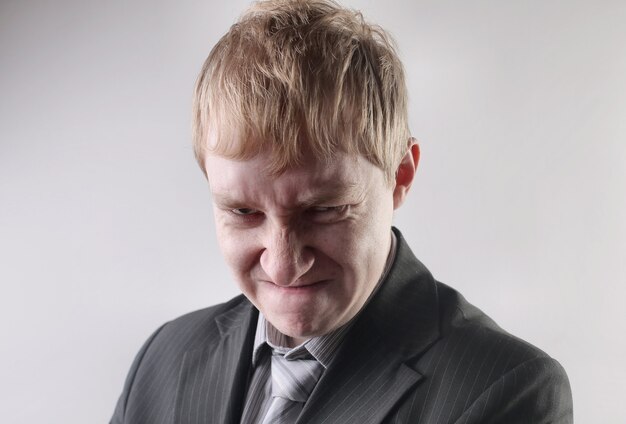 View of a male wearing a black suit with an angry facial expression