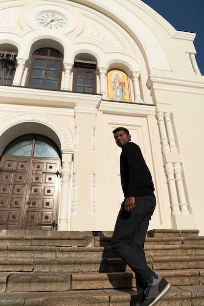 Free Photo view of man outside church on steps