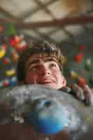 Free photo view of man practicing rock climbing on bouldering wall