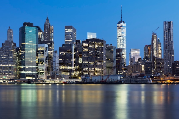 View of New York City Manhattan midtown at dusk with skyscrapers illuminated over east river