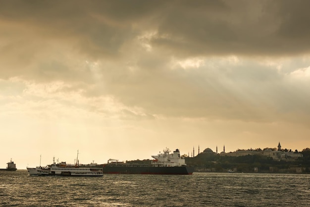 Free photo view of the old historical building with mosques towers buildings in the eastern style cargo ships tugboats in the port on the roadstead on the background of cloudy sky