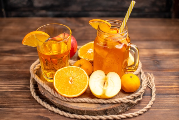 Above view of organic fresh juice in a bottle and glass served with tube and fruits on a cutting board