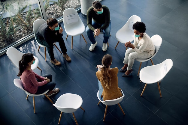 Above view of people wearing face masks during group therapy due to coronavirus pandemic