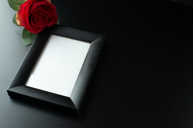 Free photo above view of picture frame with red rose on dark surface