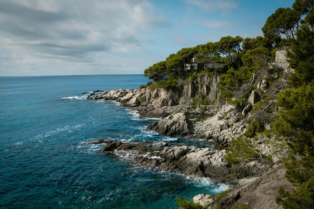 View of a rocky seashore with a cloudy blue sky