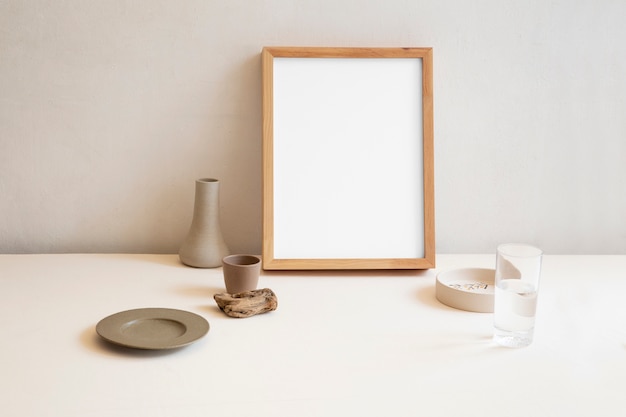 View of room decor made up of frame and plant vase with glass of water