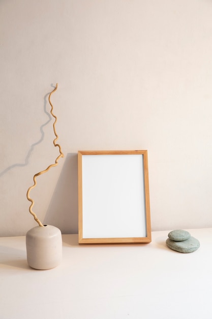 View of room decor made up of frame and plant vase with rocks