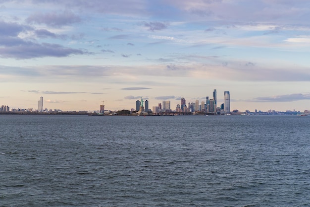 Free photo view of the statue of liberty from the water at sunset, new york, usa