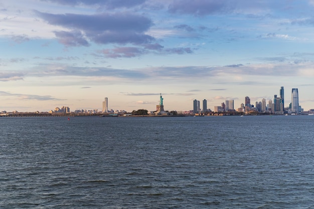 Free photo view of the statue of liberty from the water at sunset, new york, usa