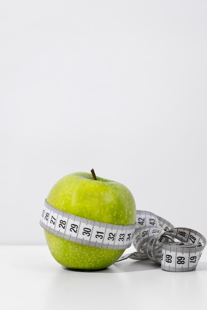 Free Photo view of tape measure with apple fruit