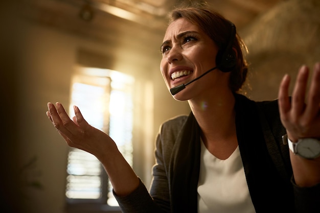 Free photo below view of upset businesswoman having some problems while working in the office