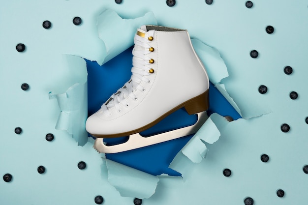 Free photo view of white ice skates with blueberries