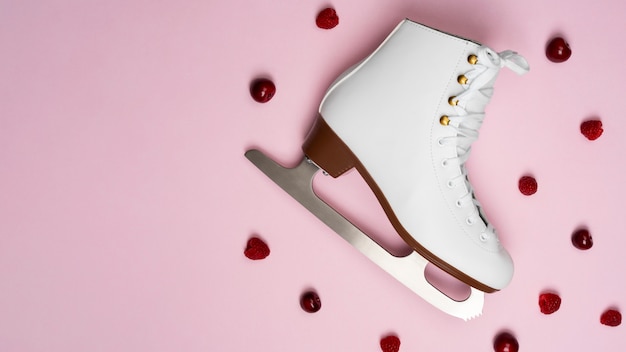 Free Photo view of white ice skates with raspberries