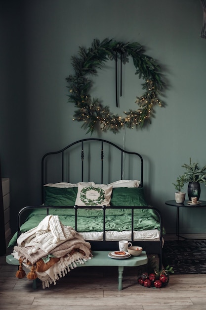 Free photo view over white modern room decorated for christmas holidays. decorated and illuminated christmas tree, fireplace with fir branch, candles and handmade paper stars in fireplace.