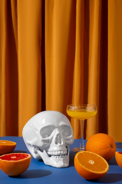 Free photo view of white skull with citrus cocktail