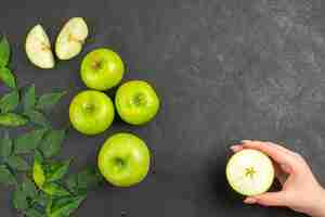 Free photo above view of whole and chopped fresh green apples and mint on black background