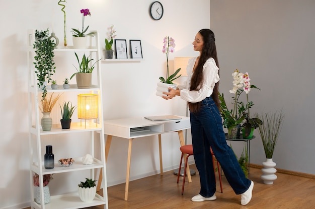 View of woman decorating her home with orchid flower