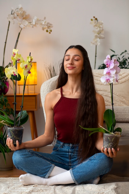 View of woman decorating her home with orchid flower