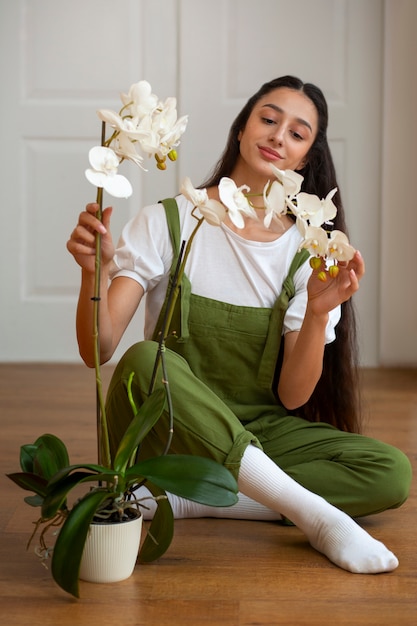 View of woman decorating her home with orchid flower