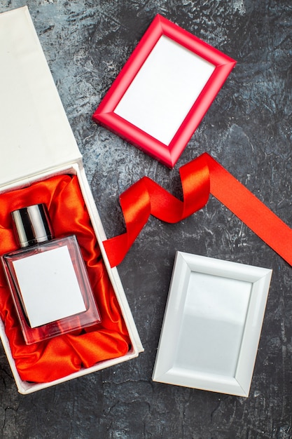 Above view of woman perfume on gift box and blue ribbon picture frames