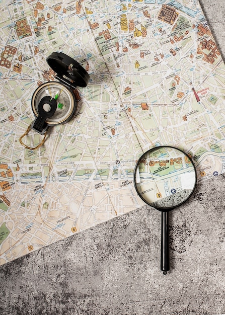 Free photo view of world travel map with compass and magnifying glass