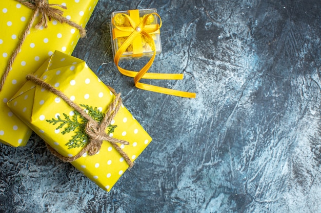 Above view of Xmas background with yellow gift boxes on dark background