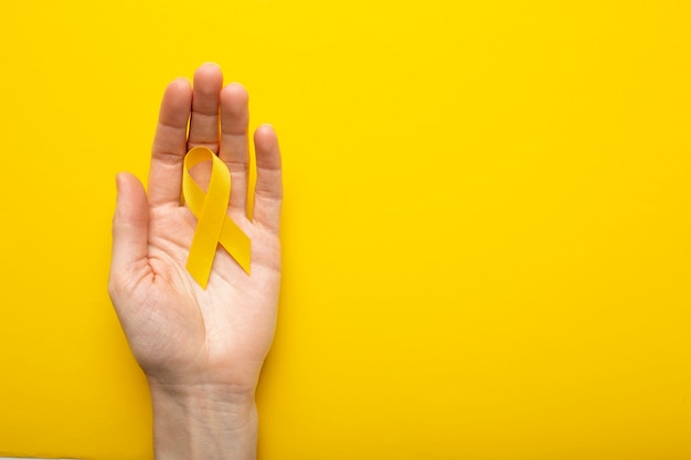 Free Photo view of yellow ribbon with human hand