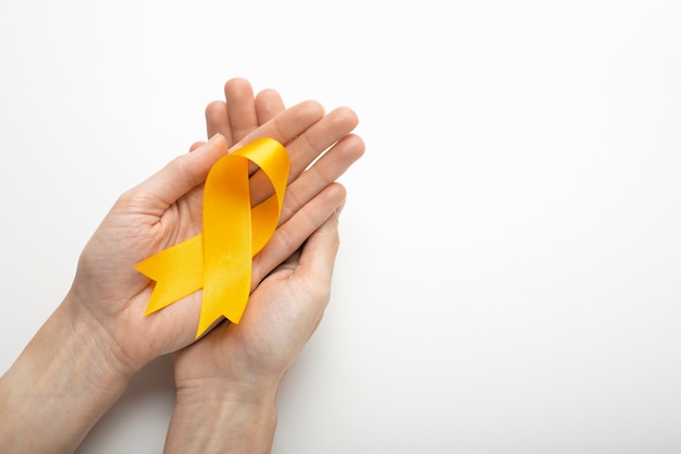 Free photo view of yellow ribbon with human hands