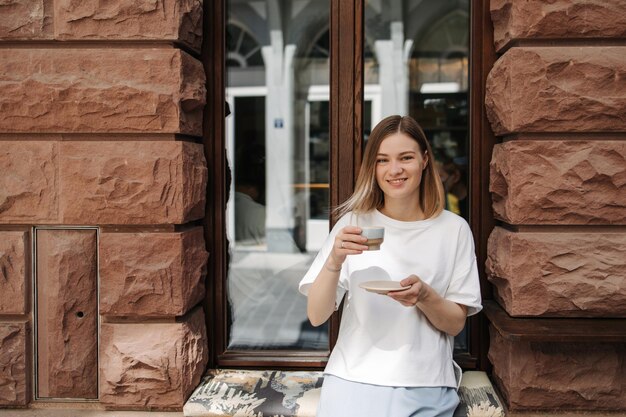 View of young woman holding cup coffee and smile