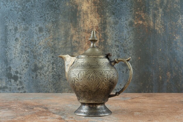 Vintage antique ancient kettle on marble background