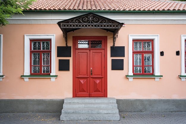 Free photo vintage architecture classical facade building with red door