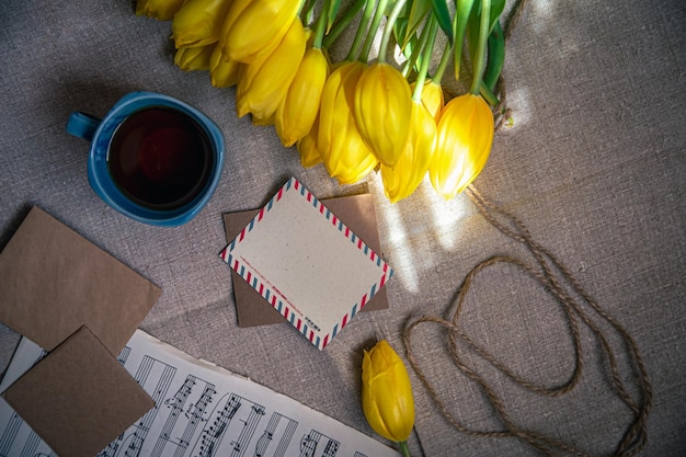 Free Photo vintage composition with a cup of tea tulips and notes flat lay