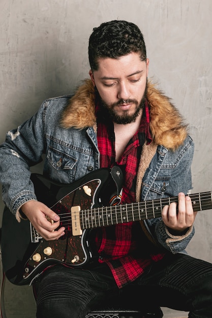 Free photo vintage dressed rocker playing  electric guitar