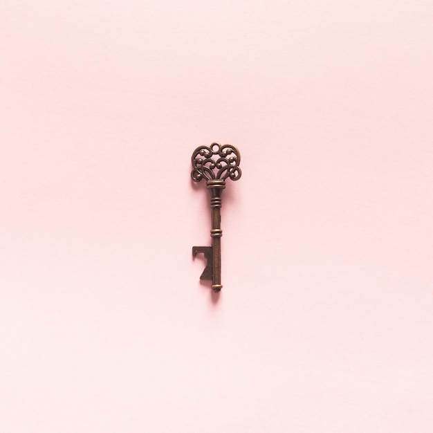 Free photo vintage key on pink background