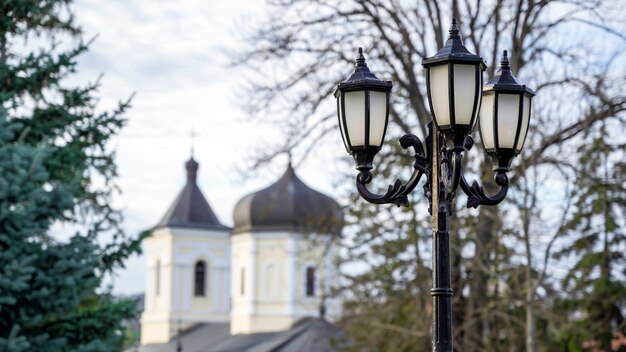 Vintage lamppost with the Stone Church and trees . Capriana Monastery, Moldova