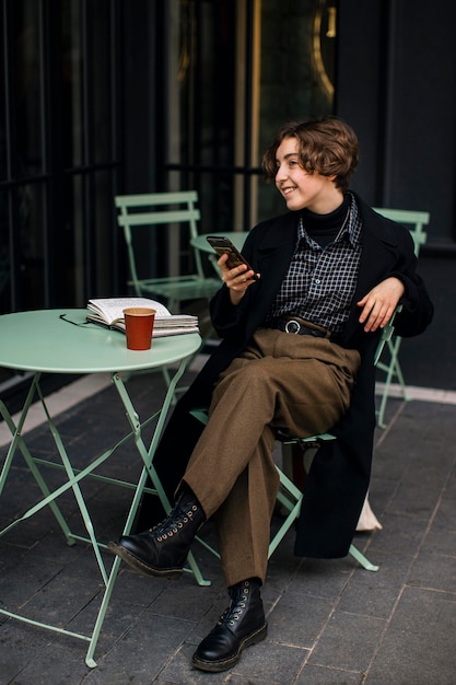 Vintage looking non binary person checking phone