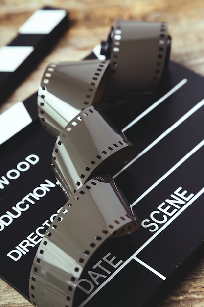 Free photo vintage reel camera tape and clapperboard on wood