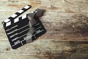 Free photo vintage reel camera tape and clapperboard on wood