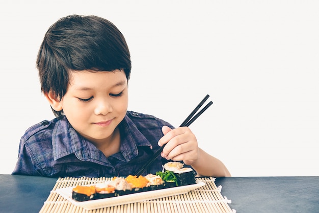 Free Photo vintage style photo of asian lovely boy is eating sushi