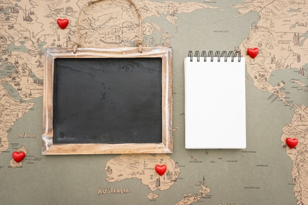 Free Photo vintage world map background with slate and notebook