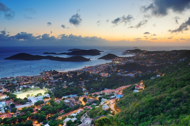 Virgin Islands St Thomas sunset mountain view with colorful cloud, buildings and beach coastline.