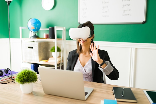 Free Photo virtual classroom. excited young teacher wearing a vr headset and giving an online lesson through virtual reality