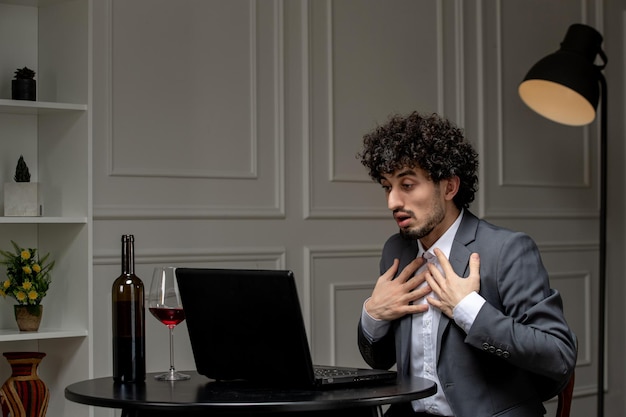 Virtual love handsome cute guy in suit with wine on a distance computer date pointing at himself